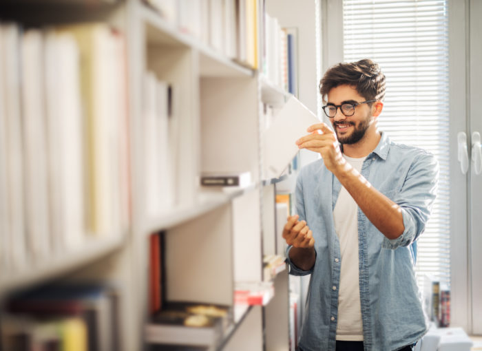 Junger Student in der Bibliothek