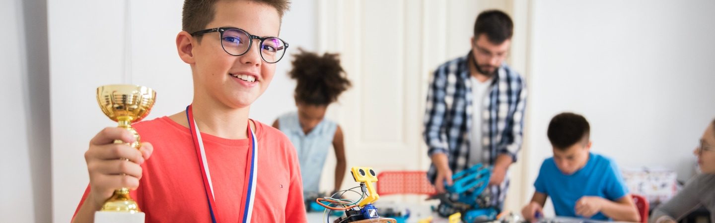Schüler mit Pokal im der Hand