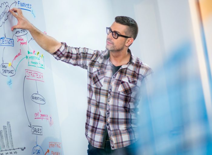 Lehrer erklärt etwas an der Schultafel