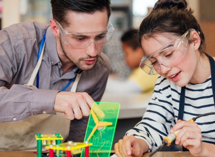 Schülerin beim Lernen mit einem Lehrer