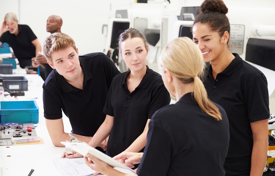 Schüler im Praktikum in einem Betrieb die etwas erklärt bekommen