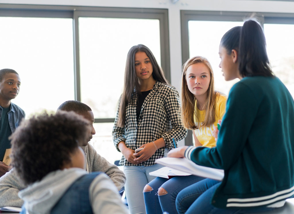 Eine Gruppe Schüler bei einer gemeinsamen Besprechung im Klassenraum