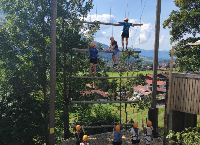 Jugendliche mit Schutzausrüstung beim Klettern