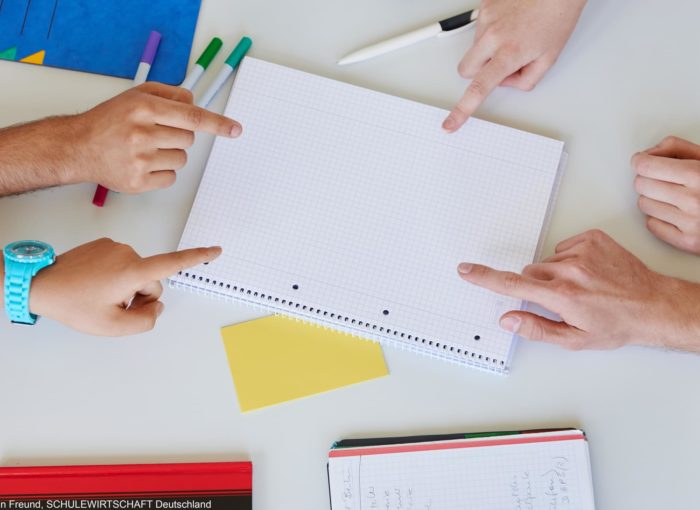 Hände die auf einen leeren Schreibblock zeigen