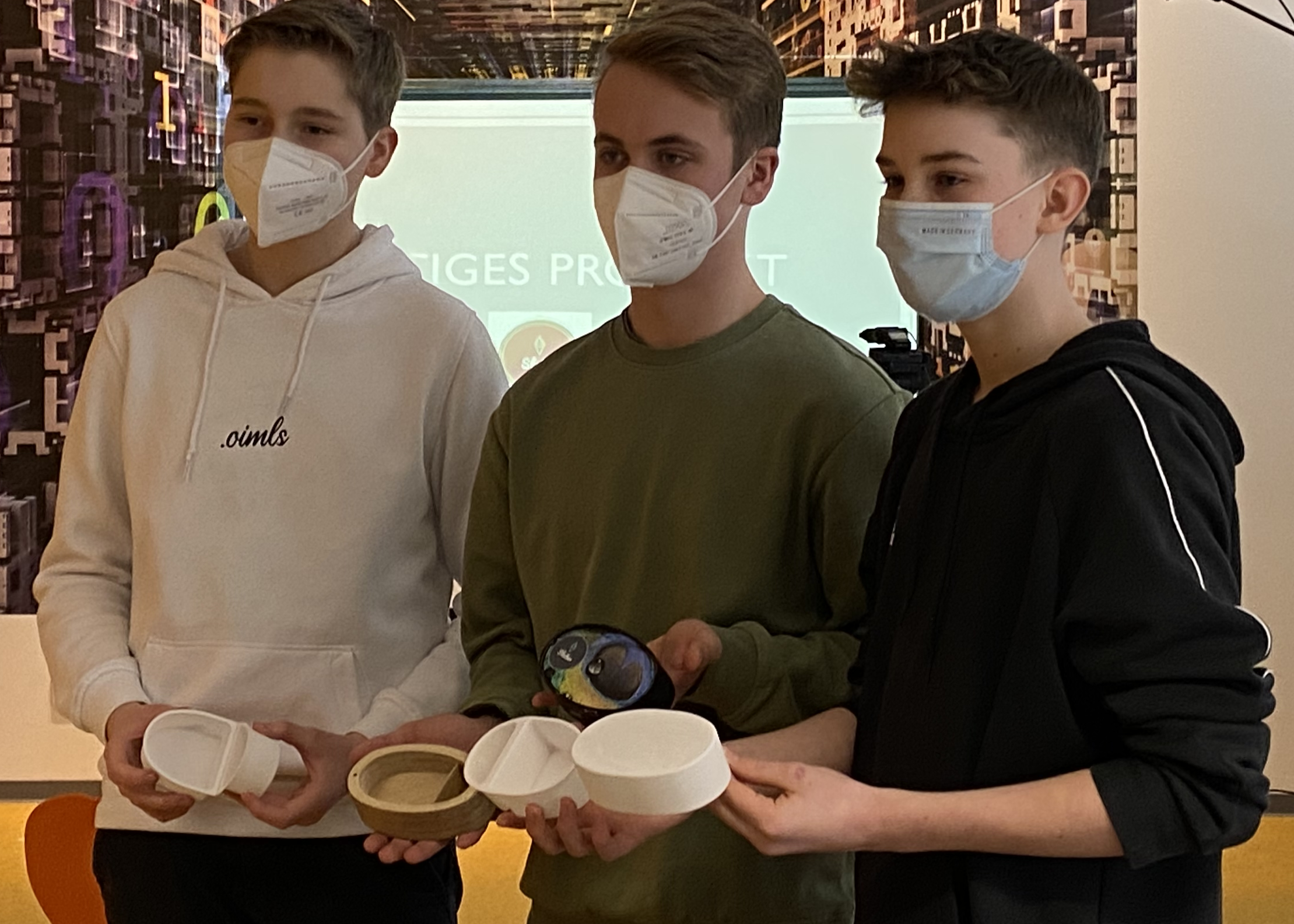 Schüler mit Maske beim Zeigen ihrer Prototypen bei einer Produktgestaltung