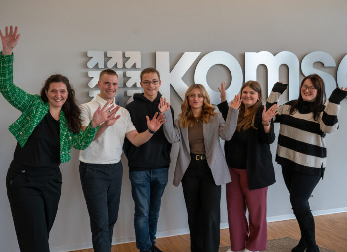 SCHULEWIRTSCHAFT Preisträger KOMSA - Gruppenbild junger Menschen vor einer Wand mit komsa-Logo