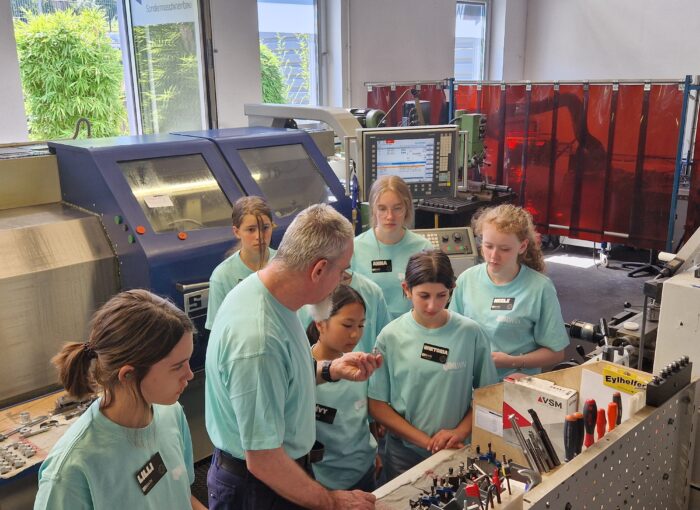 SCHULEWIRTSCHAFT Preisträger 3Win - Mitarbeiter zeigt jungen Frauen ein Werkzeug