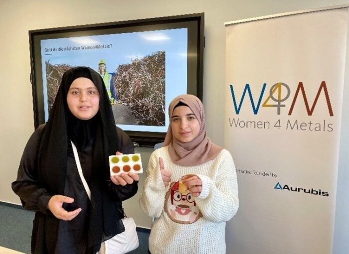 SCHULEWIRTSCHAFT Preisträger Aurubis - zwei Schülerinnen zeigen Gold- und Kupfermünzen, die sie im Projekt Women 4 Metals hergestellt haben